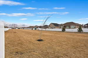 View of yard featuring a residential view, fence, and a mountain view