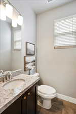 Bathroom featuring tile patterned floors, vanity, toilet, and baseboards