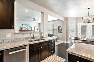 Kitchen with dark wood finished floors, dark brown cabinetry, a textured ceiling, a sink, and dishwasher