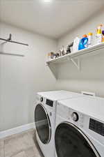 Clothes washing area featuring laundry area, washer and clothes dryer, and baseboards