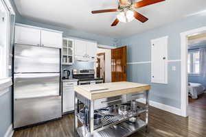 Kitchen featuring under cabinet range hood, stainless steel appliances, wood counters, white cabinets, and glass insert cabinets