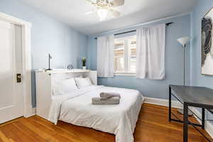 Bedroom featuring a ceiling fan, baseboards, and wood finished floors