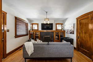 Living room featuring light wood-style flooring, a fireplace, baseboards, and visible vents