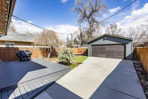 Exterior space featuring a fenced backyard, a detached garage, and an outbuilding