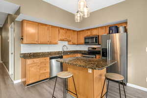 Kitchen with a sink, stainless steel appliances, backsplash, and light wood-style flooring