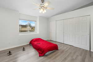 Bedroom featuring visible vents, a closet, baseboards, and wood finished floors