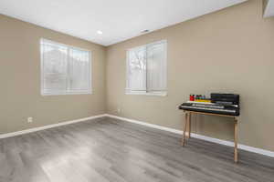 Interior space featuring visible vents, baseboards, wood finished floors, and recessed lighting