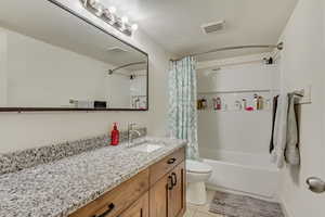 Bathroom with shower / bath combination with curtain, vanity, tile patterned flooring, and visible vents