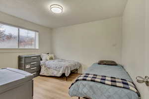 Bedroom with light wood-style flooring and a textured ceiling
