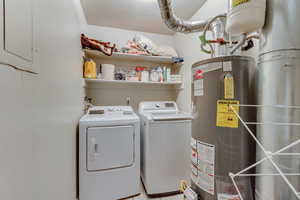 Laundry area with water heater, laundry area, and washing machine and dryer