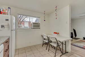 Dining space featuring baseboards, cooling unit, and light tile patterned flooring