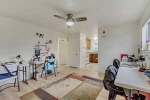 Office space with light wood-type flooring, a healthy amount of sunlight, and ceiling fan