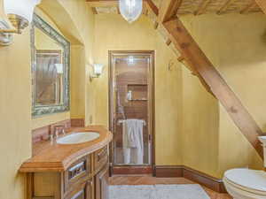 Half bath with vanity and beam ceiling