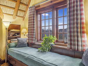 Living area with beamed ceiling and carpet floors