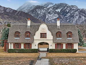 French country inspired facade with a chimney, stucco siding, and a mountain view