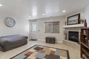 Interior space featuring a tiled fireplace, recessed lighting, visible vents, and baseboards