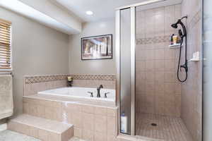 Bathroom featuring a garden tub, a shower stall, and recessed lighting