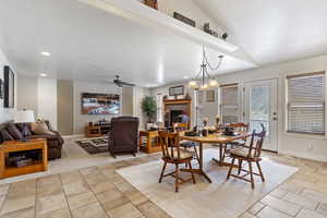 Dining area featuring baseboards, a ceiling fan, lofted ceiling, a fireplace, and recessed lighting