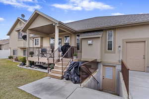 Exterior space with a shingled roof, a front yard, and stucco siding