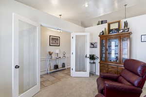 Living area featuring carpet, french doors, and lofted ceiling