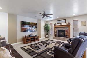 Living area featuring carpet, a textured ceiling, a tiled fireplace, and recessed lighting