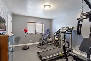 Workout room with baseboards and a textured ceiling