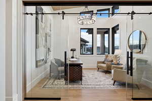 Sitting room with wood finished floors, baseboards, and a barn door