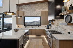 Kitchen featuring a sink, appliances with stainless steel finishes, wall chimney exhaust hood, decorative backsplash, and open shelves