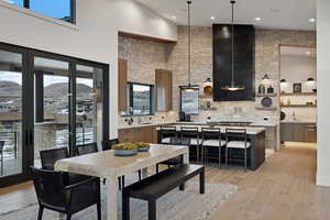 Dining area featuring a mountain view, light wood-type flooring, a towering ceiling, and recessed lighting