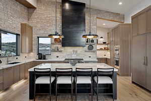 Kitchen featuring a breakfast bar area, extractor fan, a sink, backsplash, and open shelves