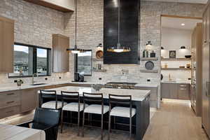 Kitchen featuring a breakfast bar, open shelves, tasteful backsplash, a sink, and light wood-type flooring