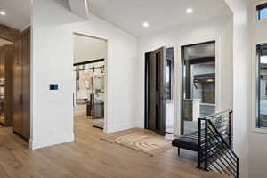 Hallway featuring recessed lighting, light wood-type flooring, and baseboards