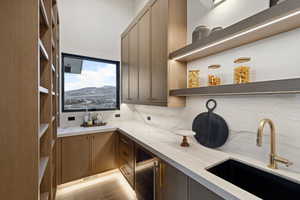 Bar featuring wine cooler, backsplash, a sink, and visible vents