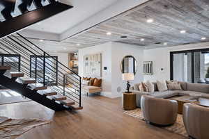 Living room with wooden ceiling, wood-type flooring, stairs, and recessed lighting