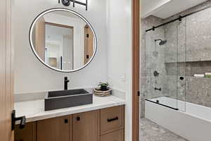 Bathroom featuring bath / shower combo with glass door and vanity