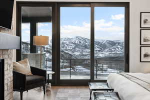 Bedroom with floor to ceiling windows, a mountain view, and wood finished floors