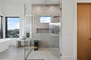 Full bathroom with a stall shower, a freestanding tub, and tile patterned floors