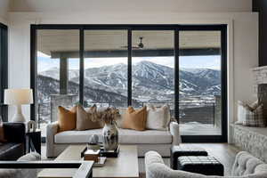 Living room featuring ceiling fan, plenty of natural light, a mountain view, and wood finished floors