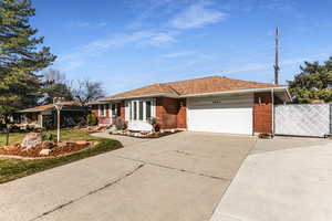 View of front of home with a garage, concrete driveway, brick siding, and a shingled roof