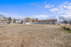 View of yard with an outdoor structure and fence