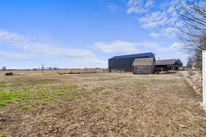 View of yard featuring an outbuilding, a pole building, and a rural view