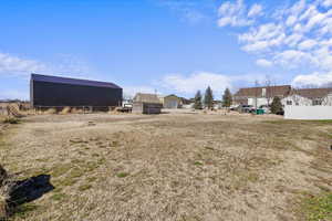 View of yard featuring an outbuilding and fence