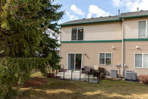 Back of house featuring a patio, central AC unit, and a lawn