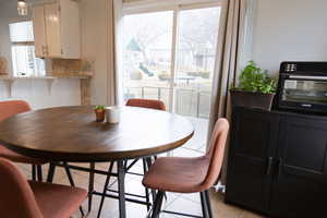 Dining area featuring light tile patterned floors and a toaster