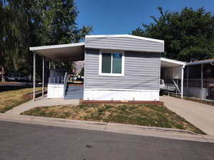 View of front of property featuring an attached carport and concrete driveway