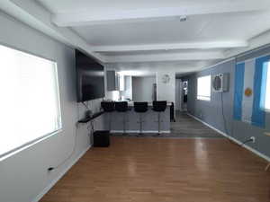 Interior space featuring wood finished floors, beam ceiling, and baseboards