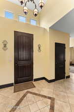 Foyer with plenty of natural light, baseboards, and light tile patterned floors