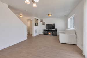 Living room with light wood-type flooring, visible vents, and baseboards