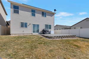 Back of property with a patio, a lawn, and a fenced backyard