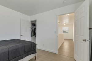 Bedroom with light wood finished floors and baseboards